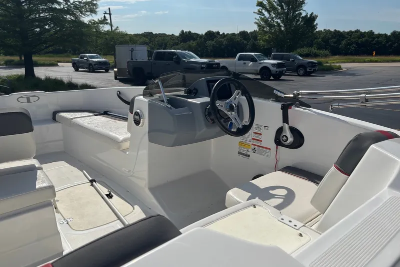 Slide: The Image of 2024 Tahoe T16 boat interior with steering wheel and seating in a parking lot. - 1