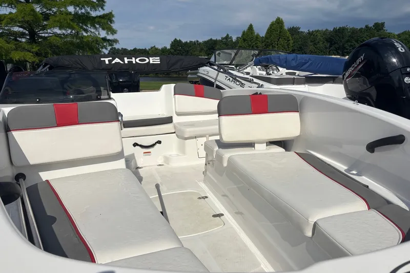Slide: The Image of 2024 Tahoe T16 boat interior with white and red seating, parked outdoors. - 7
