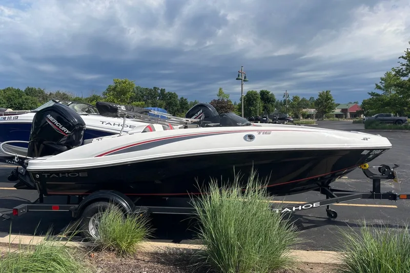 Slide: The Image of 2024 Tahoe T16 boat on trailer, parked outdoors under cloudy sky. - 3