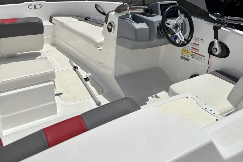 Slide: The Image of 2024 Tahoe T16 boat interior with white and red seating, steering wheel, and control panel. - 6