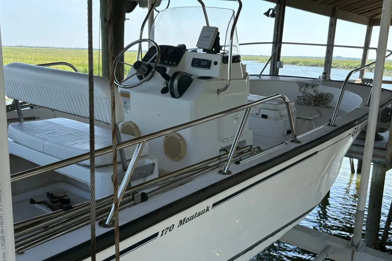 Slide: The Image of Un Boston Whaler 170 Montauk 2014 en un muelle cubierto. Presenta un cockpit abierto y timón. - 6