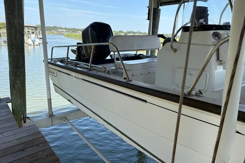 The Image of Un Boston Whaler 170 Montauk de 2014 está suspendido en un elevador sobre el agua. - 1