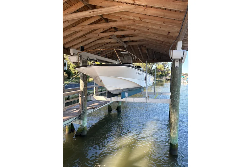 Slide: The Image of Ein weißes Boot, ein Boston Whaler 170 Montauk von 2014, hängt in einem überdachten Bootshaus über dem Wasser. - 8