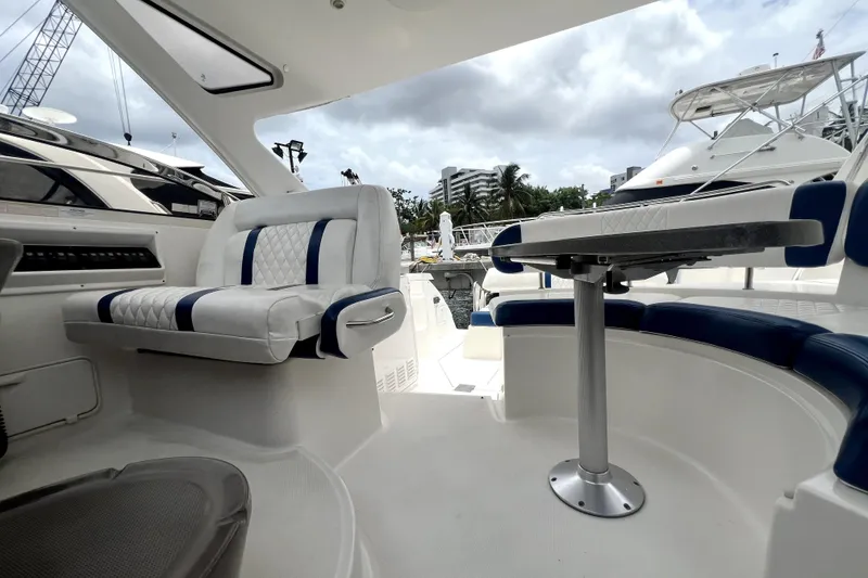Slide: The Image of 2006 Regal Commodore 3560 IB yacht interior with plush seating and table, docked at marina. - 70
