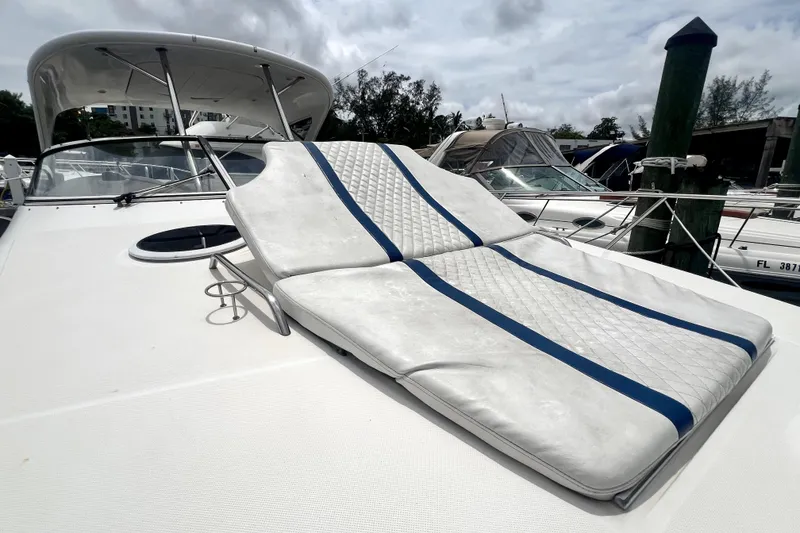 Slide: The Image of 2006 Regal Commodore 3560 IB yacht with cushioned sunbed on deck, docked at marina. - 58