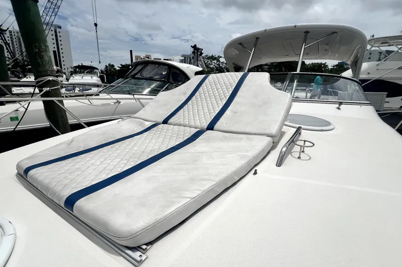 Slide: The Image of 2006 Regal Commodore 3560 IB yacht with cushioned sunbed on deck, docked at marina. - 53