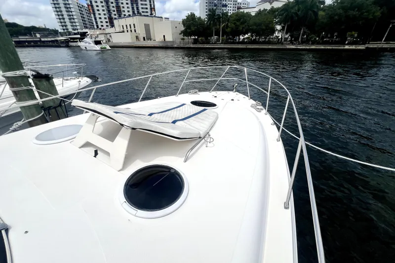 Slide: The Image of 2006 Regal Commodore 3560 IB yacht docked by urban waterfront, featuring spacious deck. - 17