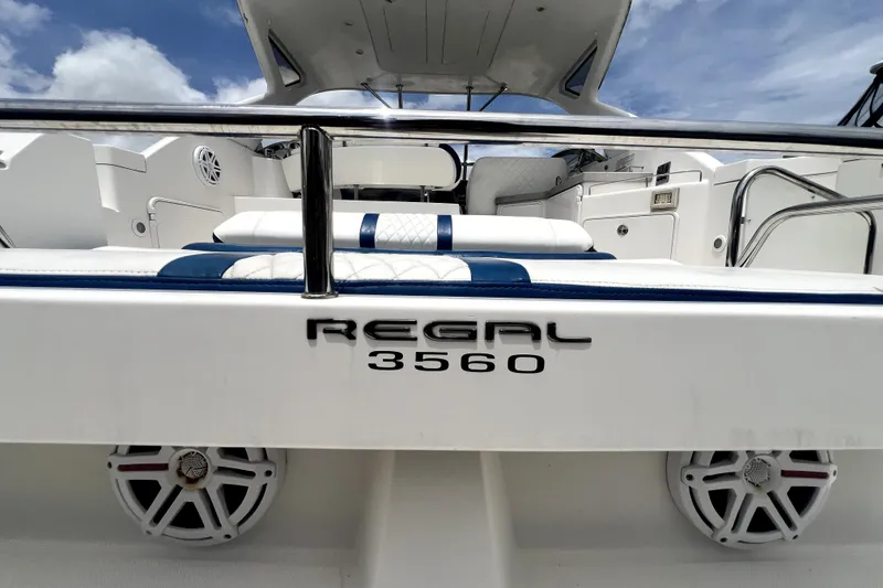 Slide: The Image of 2006 Regal Commodore 3560 IB boat interior with seating and speakers, under a clear blue sky. - 50