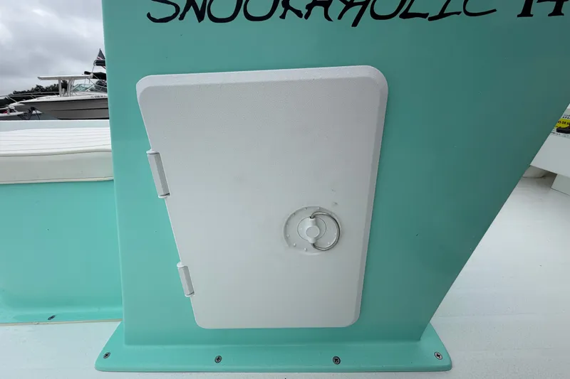 Slide: The Image of 2025 Exuma 14 Snookaholic boat with a white hatch on a teal surface. - 39