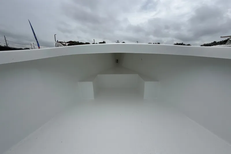 Slide: The Image of 2025 Exuma 14 Snookaholic boat interior, showcasing spacious white deck under cloudy sky. - 28