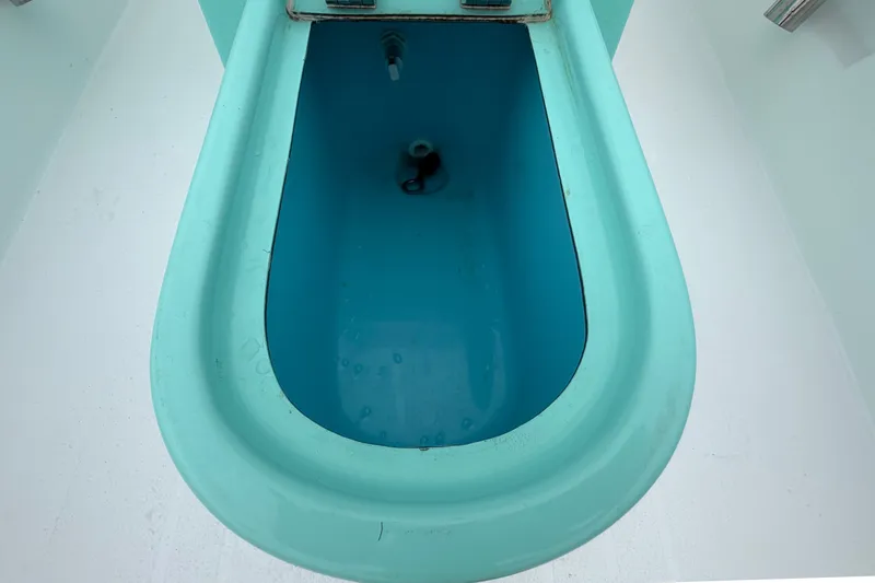 Slide: The Image of A turquoise, oval-shaped compartment in a boat, possibly a livewell or storage area. - 36