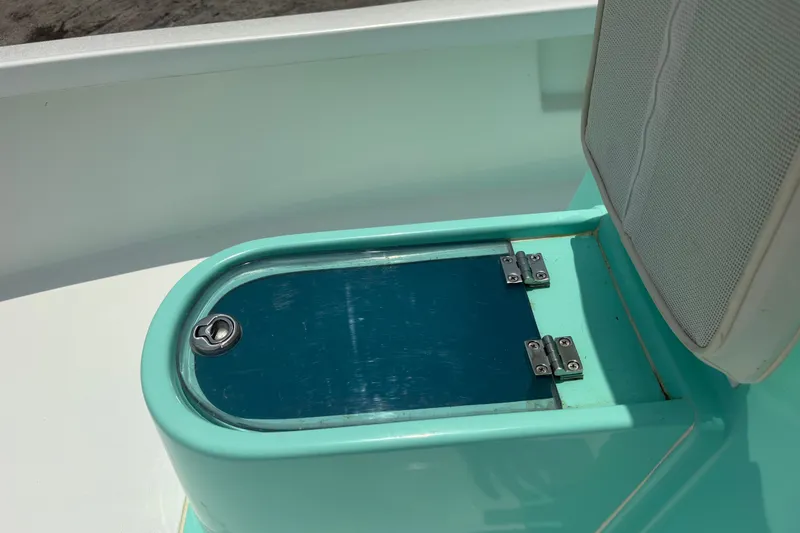 Slide: The Image of Exuma 14 Snookaholic 2025 boat seat with storage compartment, teal color, sunny day. - 16