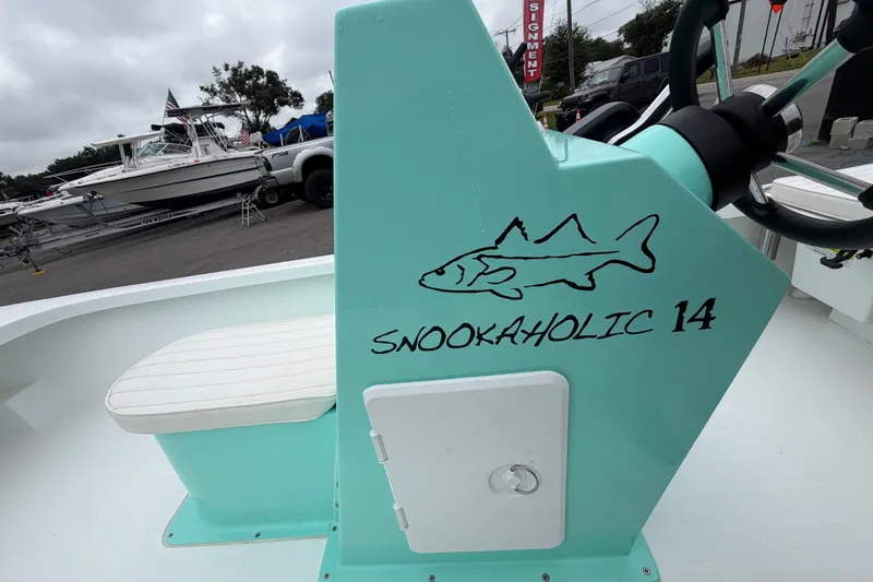 Slide: The Image of 2025 Exuma 14 Snookaholic boat with teal console and fish graphic. - 38