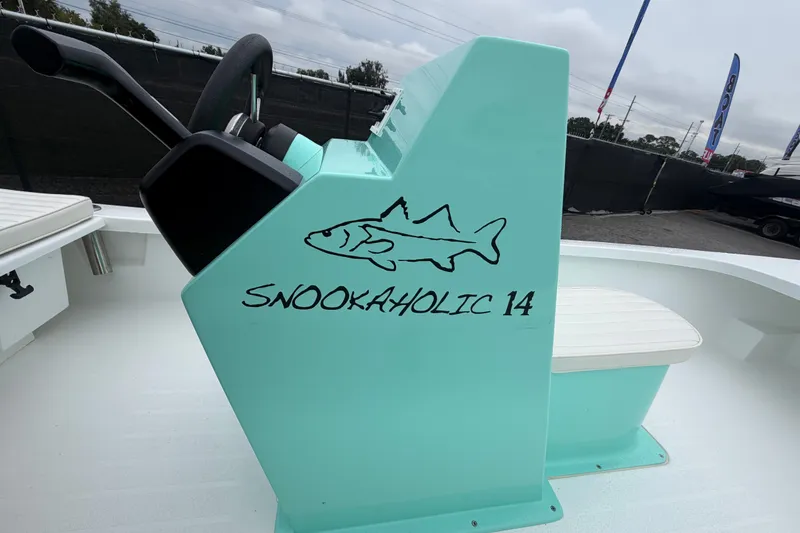 Slide: The Image of Turquoise Exuma 14 Snookaholic 2025 boat console with fish graphic and steering wheel. - 25
