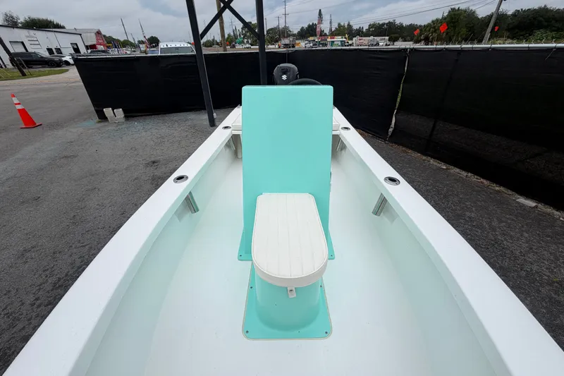 Slide: The Image of 2025 Exuma 14 Snookaholic boat interior with teal seating, parked outdoors. - 32