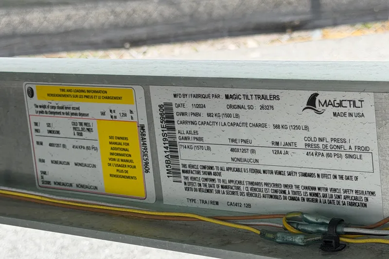 Slide: The Image of Label on Magic Tilt trailer with tire and loading information, manufactured in 2024. - 56