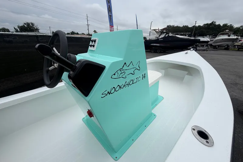 Slide: The Image of 2025 Exuma 14 Snookaholic boat with turquoise console and steering wheel. - 24