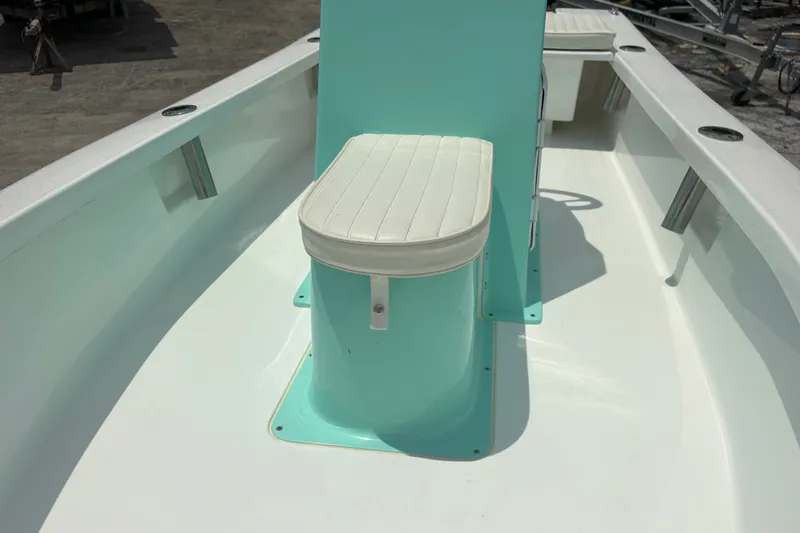 Slide: The Image of 2025 Exuma 14 Snookaholic boat interior with teal console and white cushioned seat. - 14