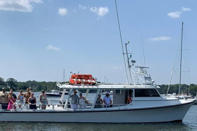 Slide: The Image of 1999 Markley 46 Chesapeake boat with passengers on deck, cruising on a sunny day. - 14