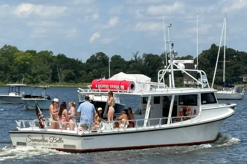 Slide: The Image of 1999 Markley 46 Chesapeake boat with passengers enjoying a sunny day on the water. - 2