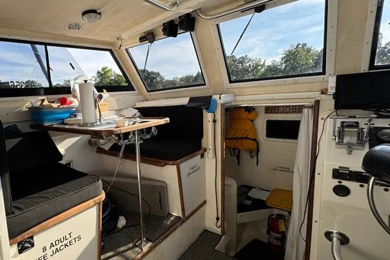 Slide: The Image of Interior of 1999 Markley 46 Chesapeake boat, featuring seating, table, and safety equipment. - 6
