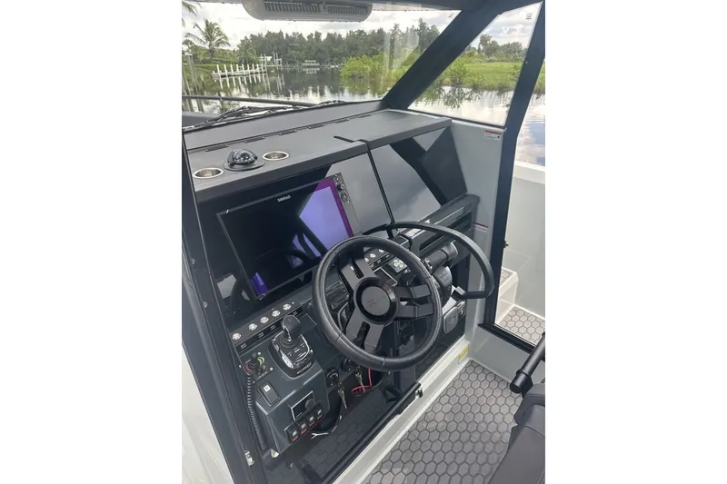 Slide: The Image of 2023 XO DFNDR 9 boat cockpit with steering wheel and navigation controls. - 14