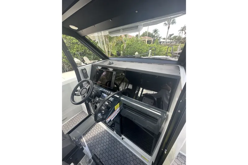 Slide: The Image of Interior view of 2023 XO DFNDR 9 boat cockpit with steering wheel and controls. - 12