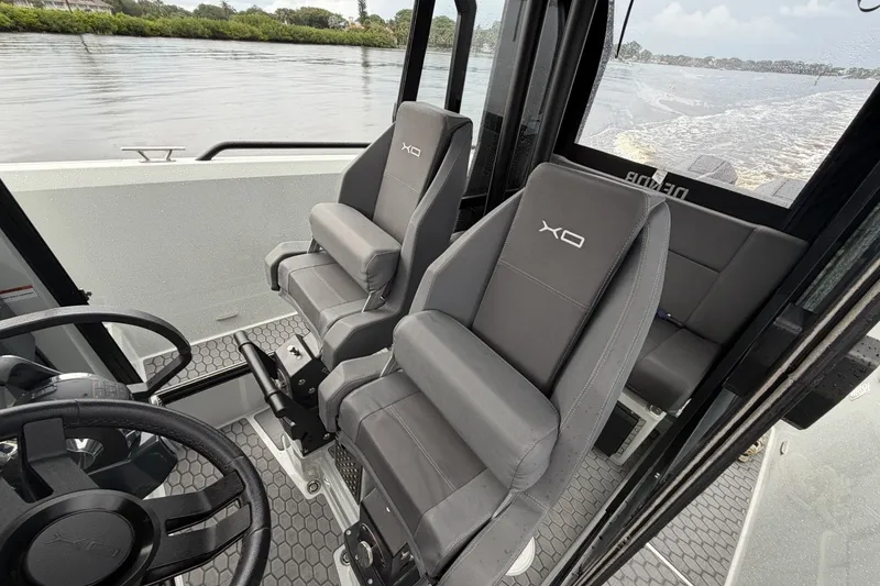 Slide: The Image of Interior of 2023 XO DFNDR 9 boat with gray seating and steering wheel. - 11