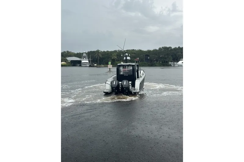 Slide: The Image of 2023 XO DFNDR 9 boat navigating a calm river under overcast skies. - 3