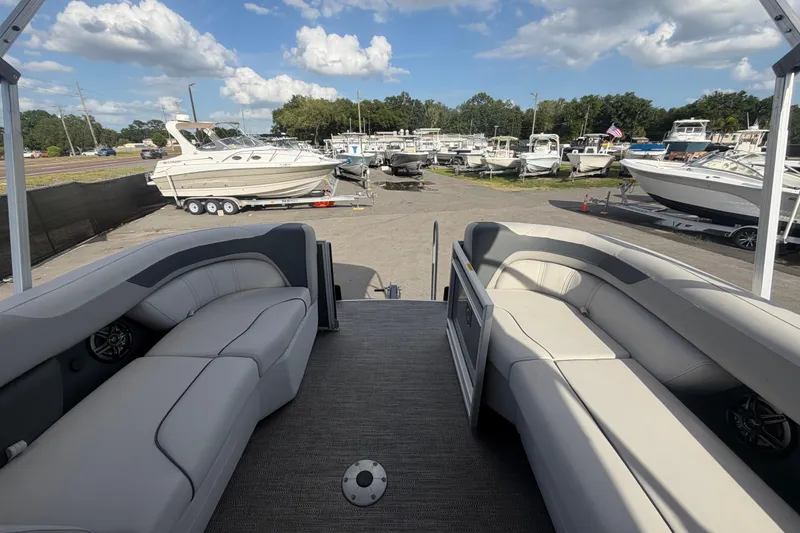 Slide: The Image of 2025 Godfrey Sweetwater 2286 SFL pontoon boat interior with docked boats in background. - 45