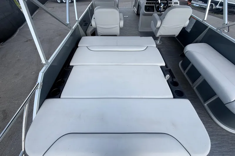 Slide: The Image of 2025 Godfrey Sweetwater 2286 SFL boat interior with white seating and cup holders. - 24