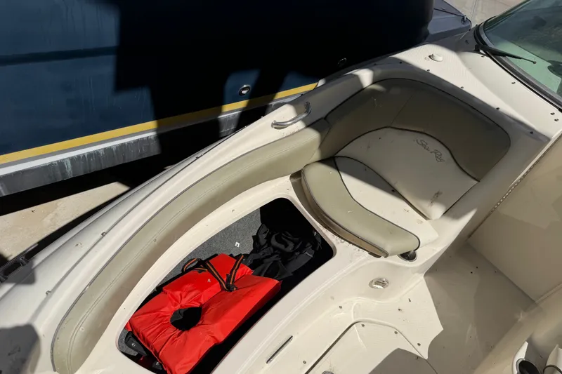 Slide: The Image of 2006 Sea Ray 240 Sundeck interior with seating and life jacket storage. - 51
