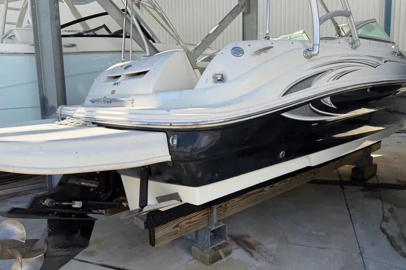 Slide: The Image of 2006 Sea Ray 240 Sundeck boat on dry dock, showcasing sleek design and powerful engine. - 10
