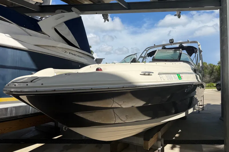Slide: The Image of 2006 Sea Ray 240 Sundeck boat on a lift, with a clear sky background. - 3