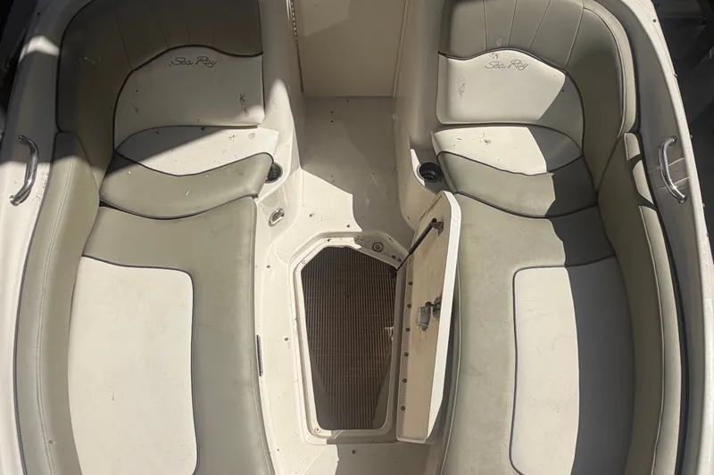 Slide: The Image of 2006 Sea Ray 240 Sundeck interior with open storage compartment and cushioned seating. - 12