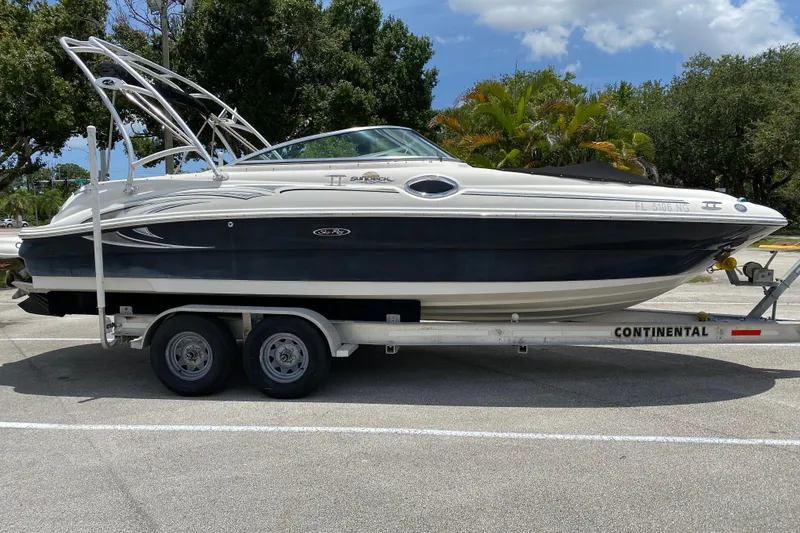 The Image of 2006 Sea Ray 240 Sundeck boat on trailer, parked outdoors. - 0