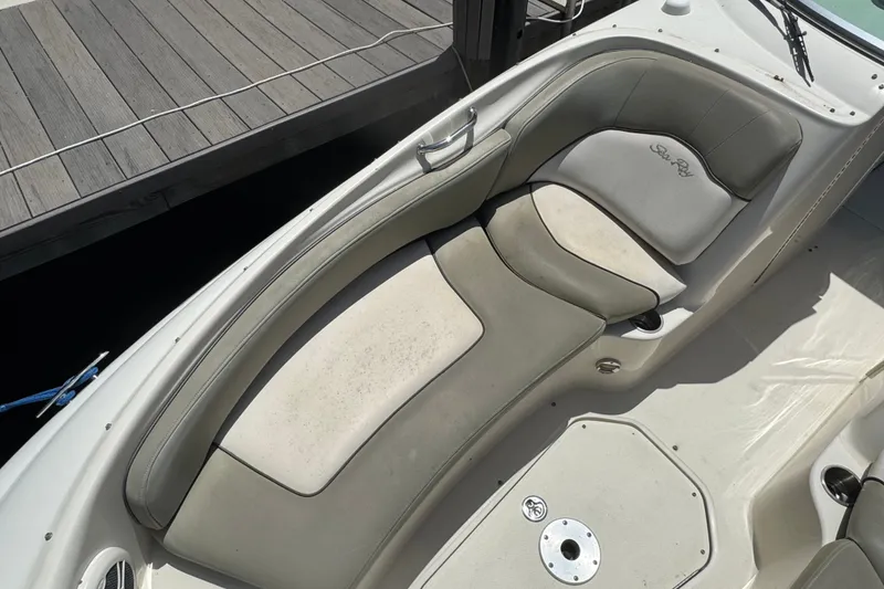 Slide: The Image of 2006 Sea Ray 240 Sundeck boat interior with cushioned seating near dock. - 7