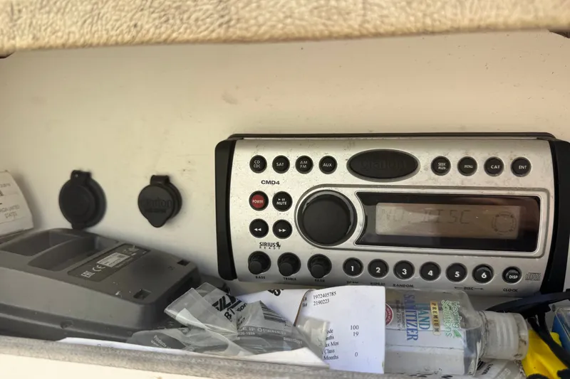 Slide: The Image of 2006 Sea Ray 240 Sundeck stereo system with controls and sanitizer bottle nearby. - 12