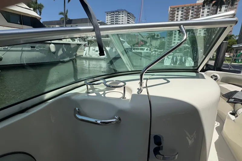 Slide: The Image of 2006 Sea Ray 240 Sundeck boat interior with windshield and cup holders. - 10