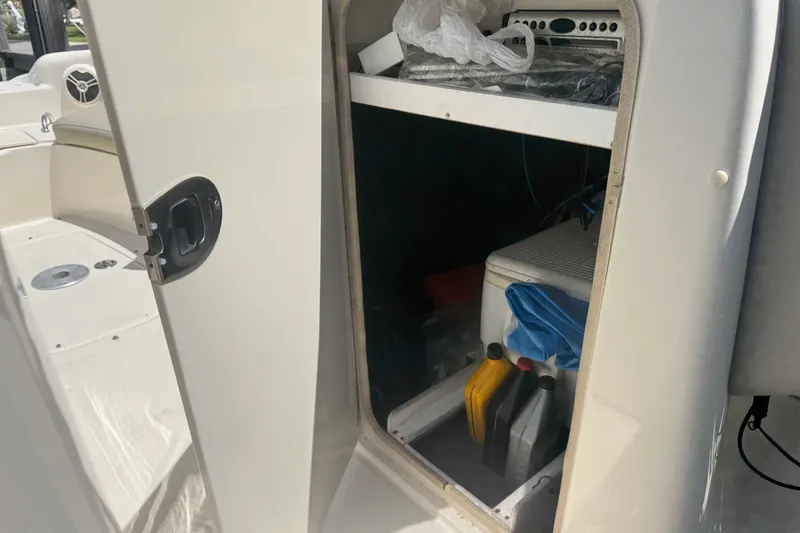 Slide: The Image of Storage compartment on a 2006 Sea Ray 240 Sundeck boat with various items inside. - 11