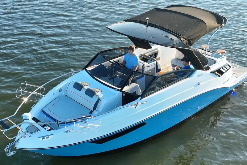 The Image of L'immagine mostra una moderna barca a motore sull'acqua con un tettuccio nero e vernice blu. - 0