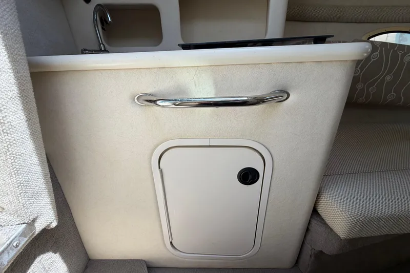 Slide: The Image of 2006 Sea Ray 250 Amberjack cabin interior with sink and storage compartment. - 36