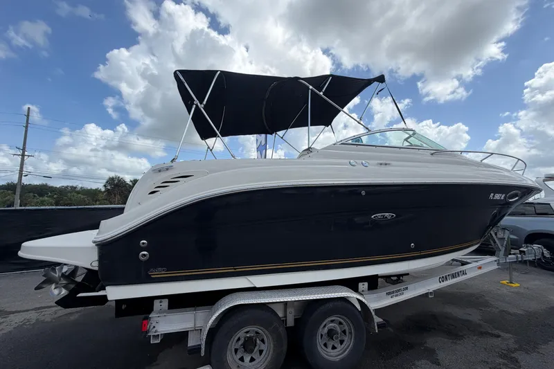 Slide: The Image of 2006 Sea Ray 250 Amberjack auf Anhänger unter blauem Himmel. - 2