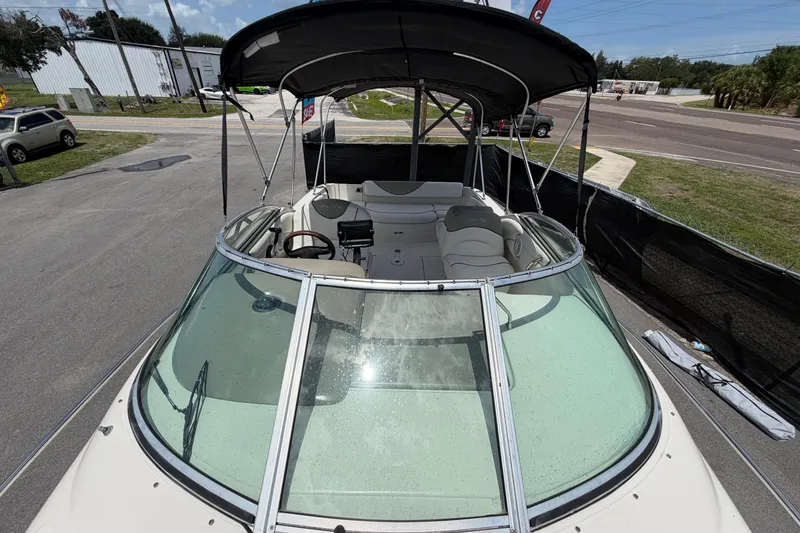 Slide: The Image of 2006 Sea Ray 250 Amberjack boat with canopy, parked on pavement. - 54