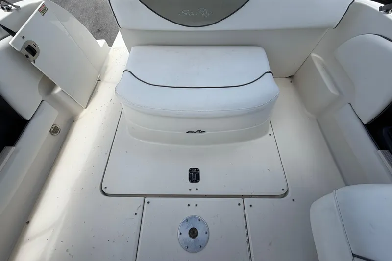 Slide: The Image of 2006 Sea Ray 250 Amberjack boat interior with white seating and storage compartment. - 59