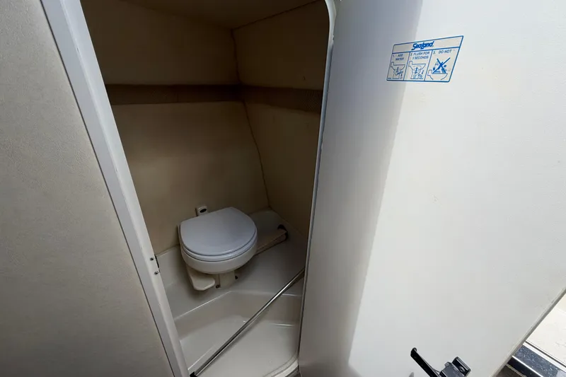 Slide: The Image of 2006 Sea Ray 250 Amberjack boat bathroom interior with toilet and instructions. - 45
