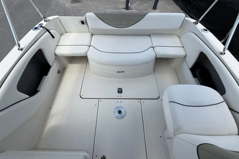 Slide: The Image of 2006 Sea Ray 250 Amberjack boat interior with white seating and storage compartments. - 57