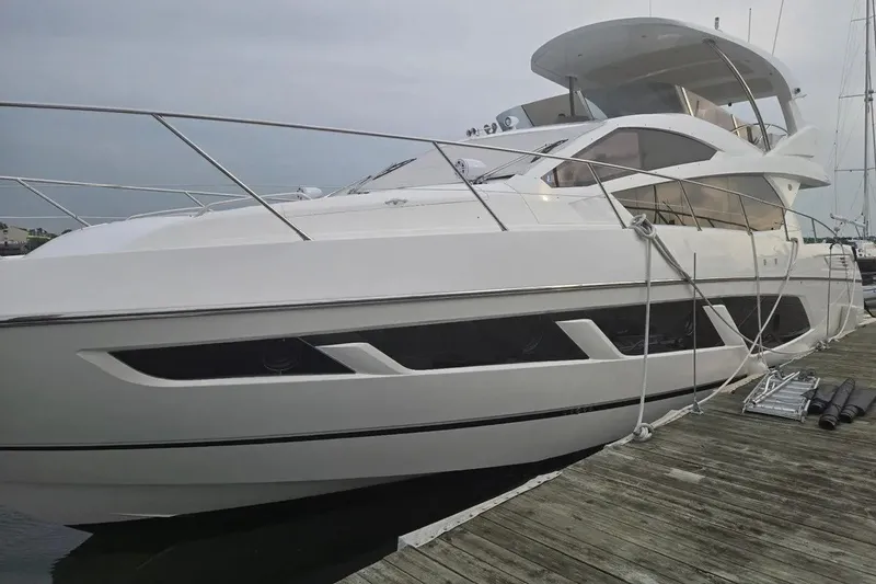 Slide: The Image of 2016 Sunseeker Manhattan 65 yacht docked at a marina, showcasing sleek design and luxury. - 29