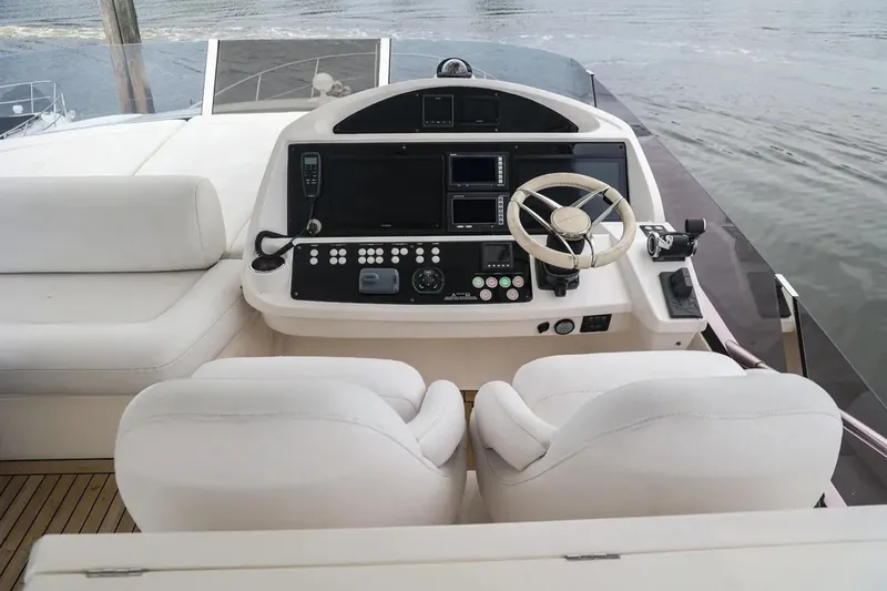 Slide: The Image of Cockpit of 2016 Sunseeker Manhattan 65 yacht with modern controls and white seating. - 23