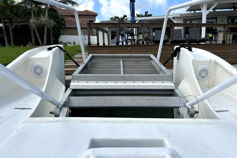 Slide: The Image of 2014 Custom Exuma Catamaran 32 with deck view, docked near a waterfront property. - 27